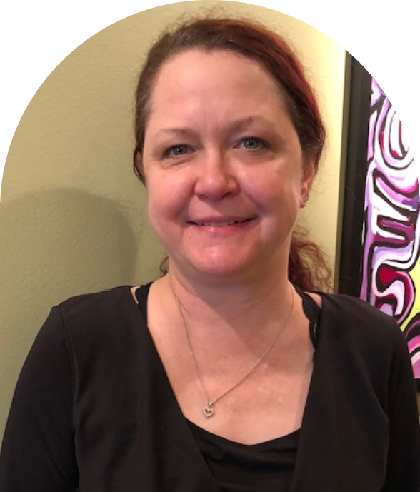 A woman with red hair and black shirt smiling.