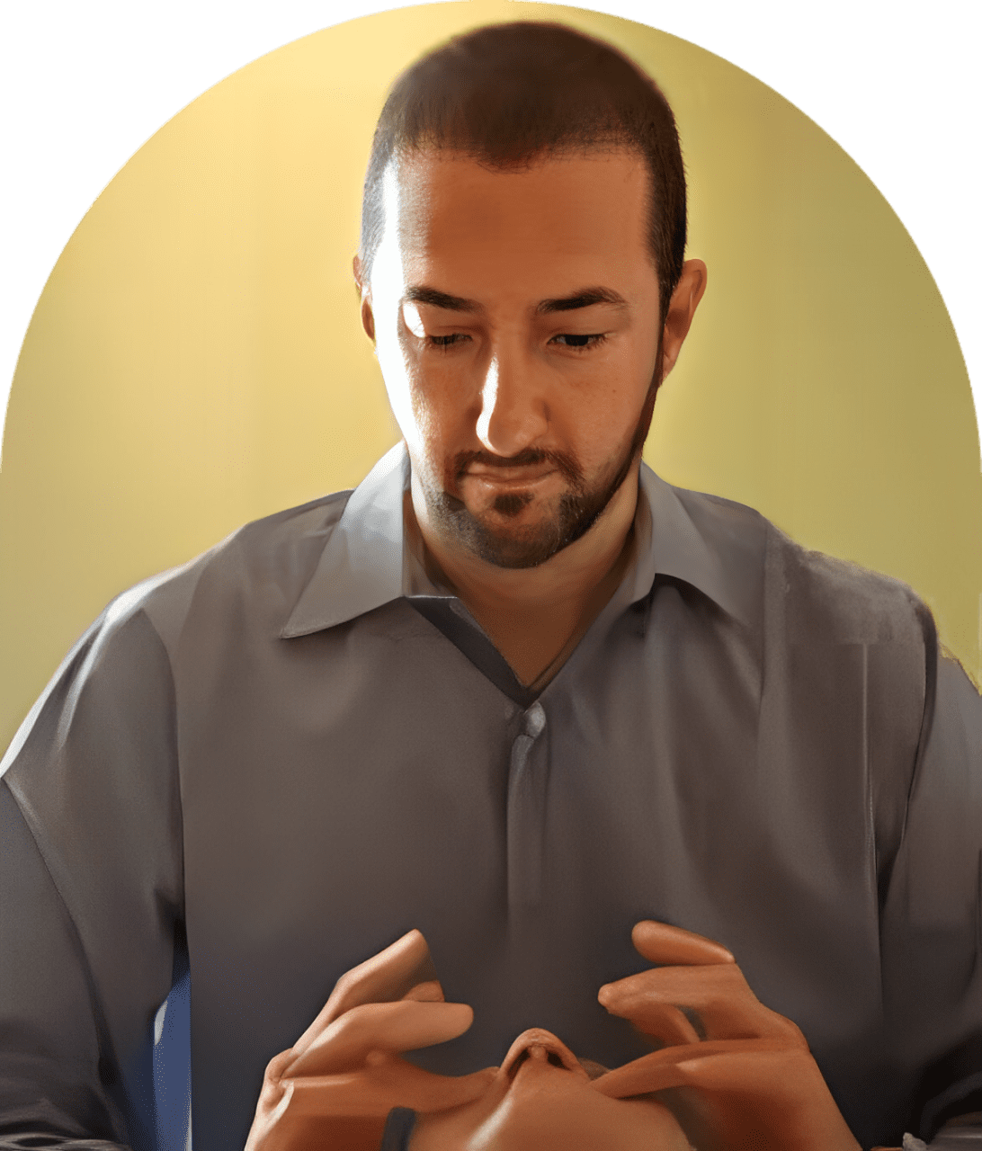 A man in grey shirt holding something up to his face.